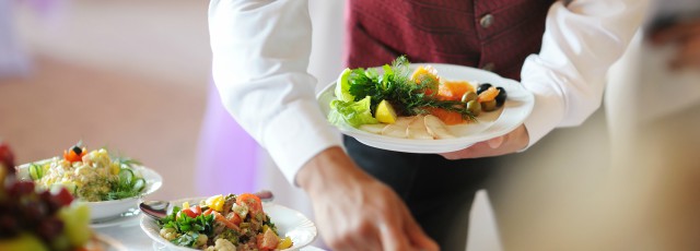 Garçonete De Restaurante Servindo Mesa Com Comida Imagem de Stock